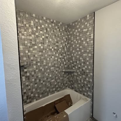 Mosaic tile tub surround installation in progress