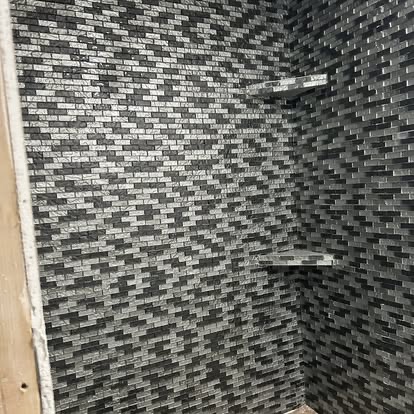 Dark mosaic tile shower surround