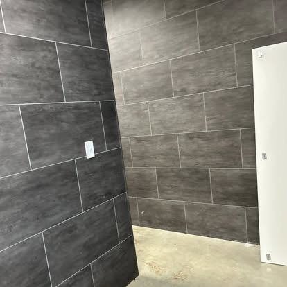 Large-format gray tile wall installation with clean grout lines