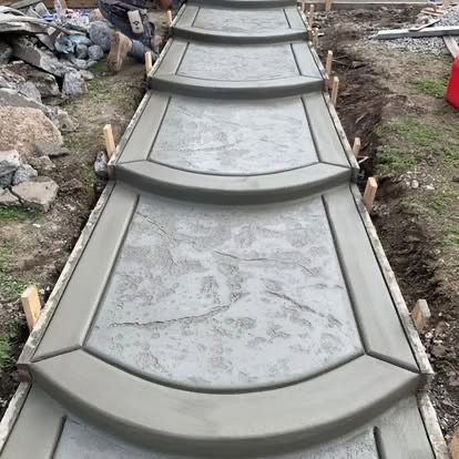 Freshly poured stamped concrete walkway with stone pattern